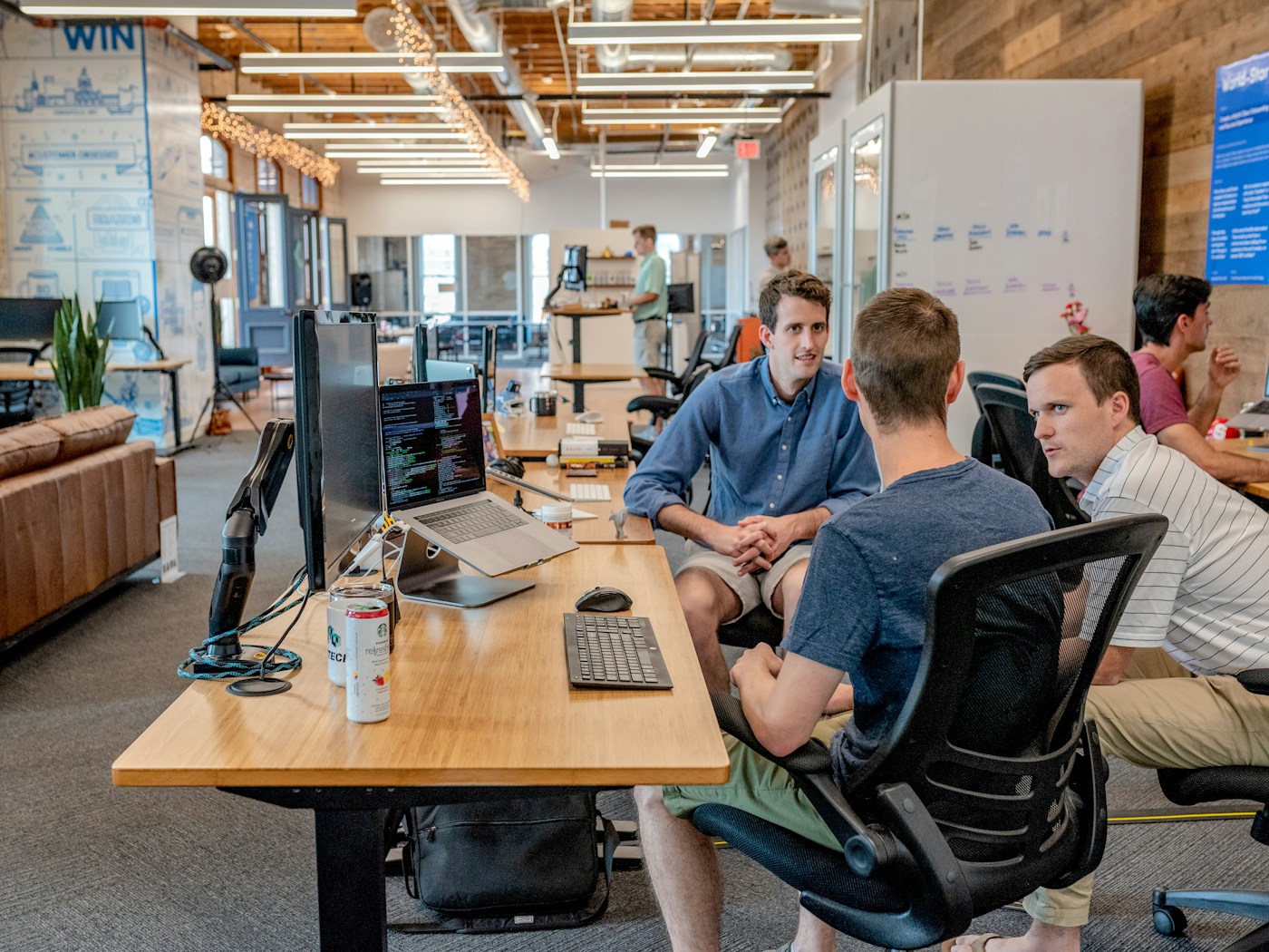 Colleagues talking through a project at their desks in an open-plan office